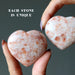 hands holding 2 Sunstone Hearts