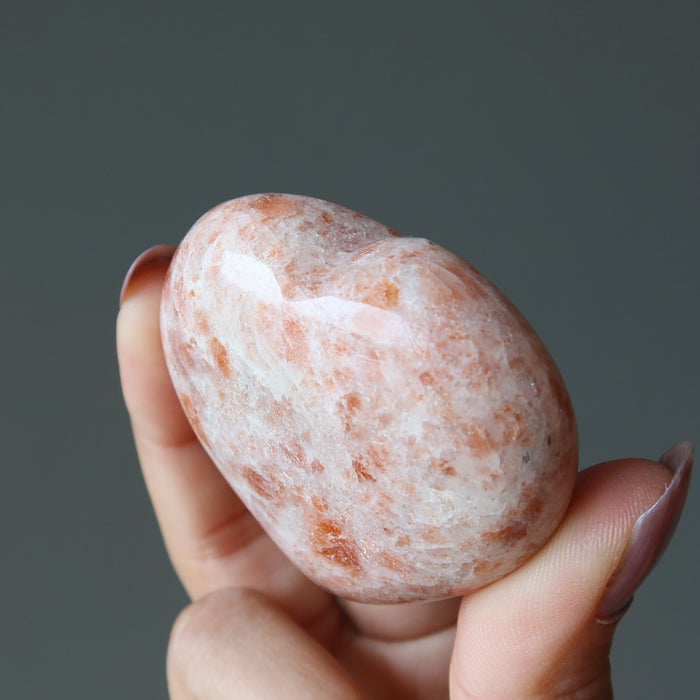 finger tips holding Sunstone Heart 