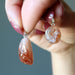 hand holding two Sunstone Pendant Drop pendants