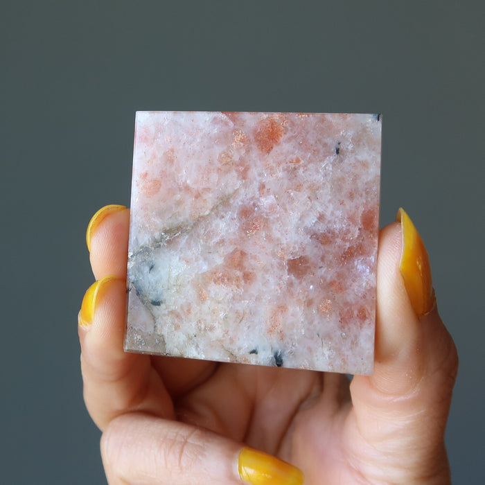 hand holding sunstone pyramid