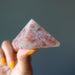hand holding sunstone pyramid