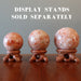three sunstone spheres on wood display stands, stands sold separately