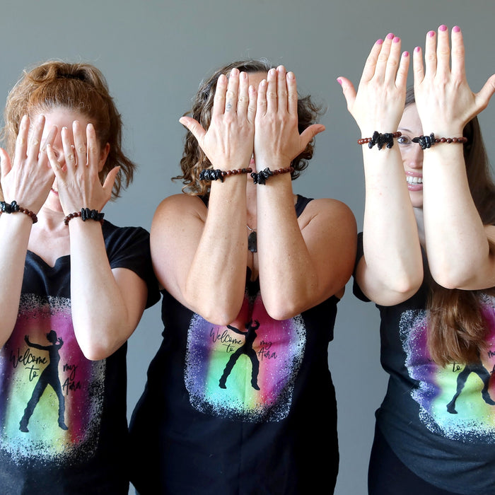 three females wearing tektite obsidian bracelets and satin crystals shirts