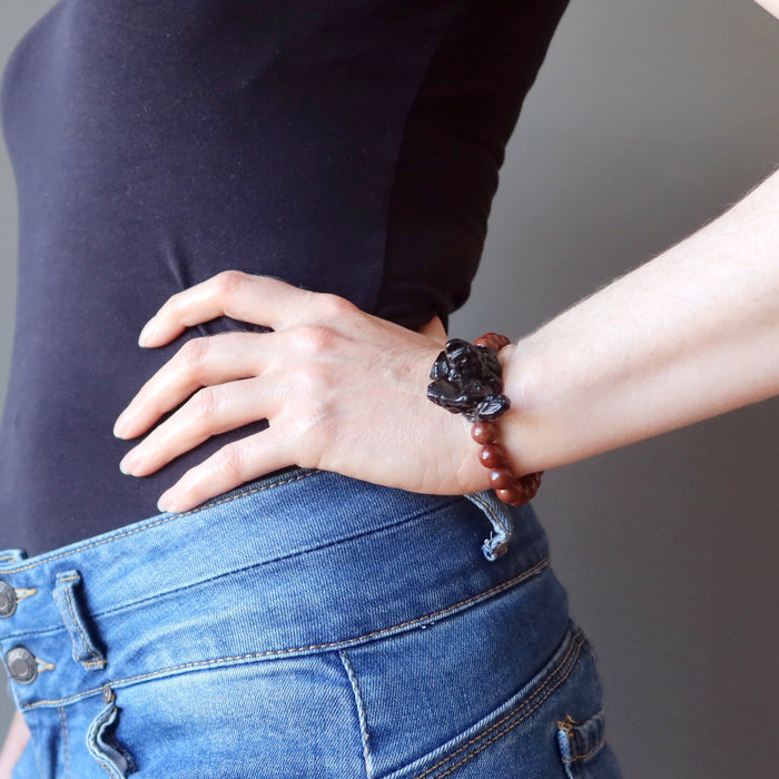 woman with hand on hip wearing tektite obsidian bracelet