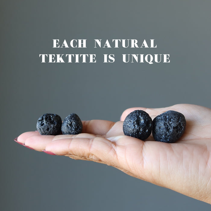 model palm displayng two pairs of  Round Black Tektite Meteorites 