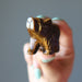 finger tips holding Tigers Eye Bear 