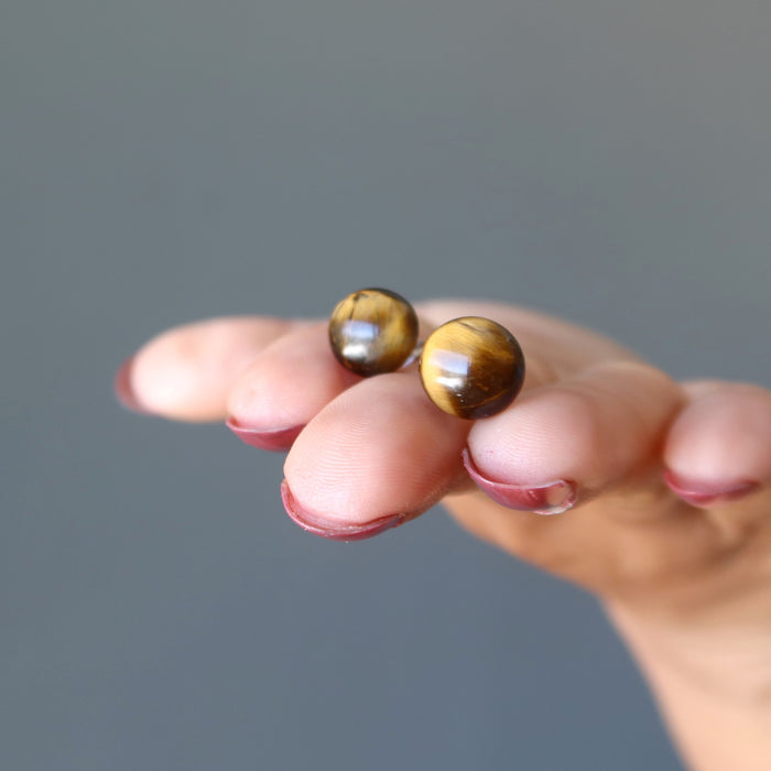 hand holding tigers eye stud earrings