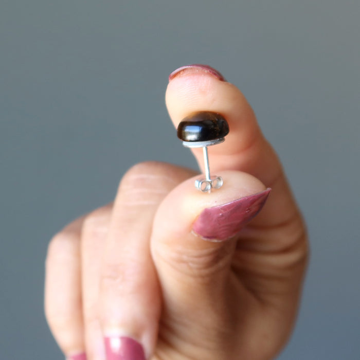 hand holding tigers eye stud earrings