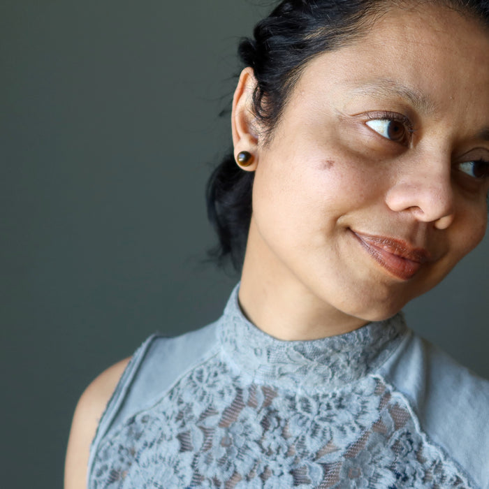 woman modeling tigers eye stud earrings