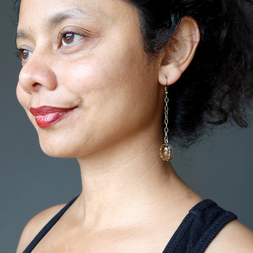 sheila of satin crystals wearing long golden brown tigers eye oval stones in antique brass chain earrings