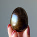 finger tips holding Tigers Eye Egg