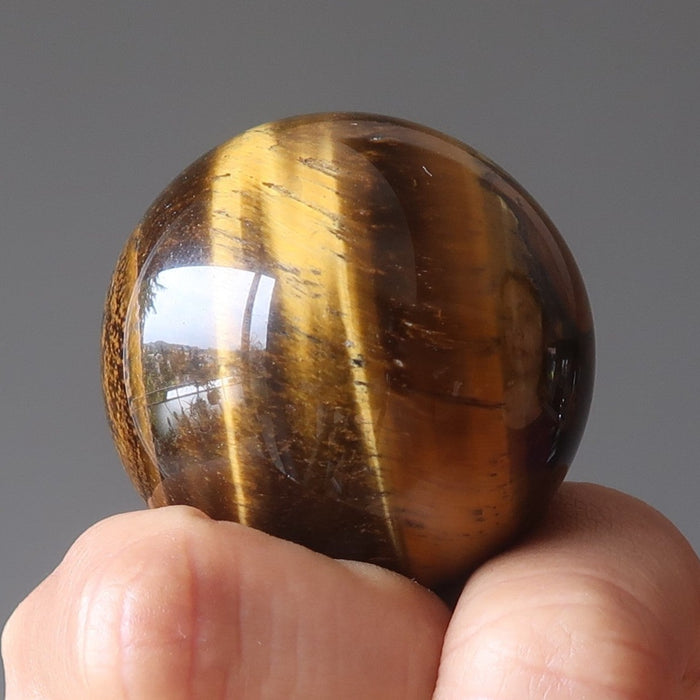 hand holding golden tigers eye sphere