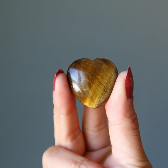hand holding golden tigers eye heart