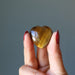 hand holding golden tigers eye heart