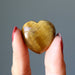 hand holding golden tigers eye heart