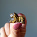 finger tips holding up 1" Tigers Eye Lion
