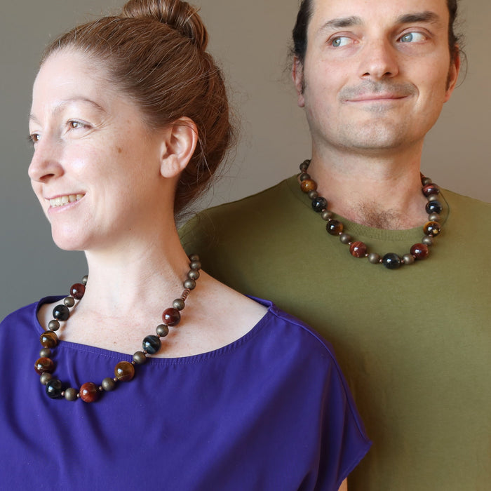 couple wearing golden, blue and red tigers eye on antiqued beaded necklace