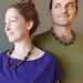 couple wearing golden, blue and red tigers eye on antiqued beaded necklace