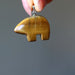 hand holding golden brown tigers eye bear fetish pendant