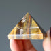hand holding Tigers Eye Pyramid 