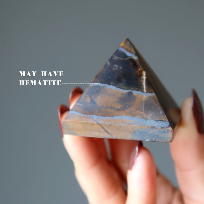 hand holding Tigers Eye Pyramid 