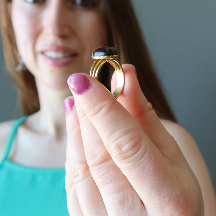 female model holding tigers eye gold ring