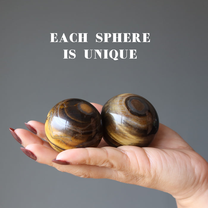palm holding 2 Tigers Eye  with Hematite Sphere