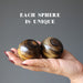 palm holding 2 Tigers Eye  with Hematite Sphere