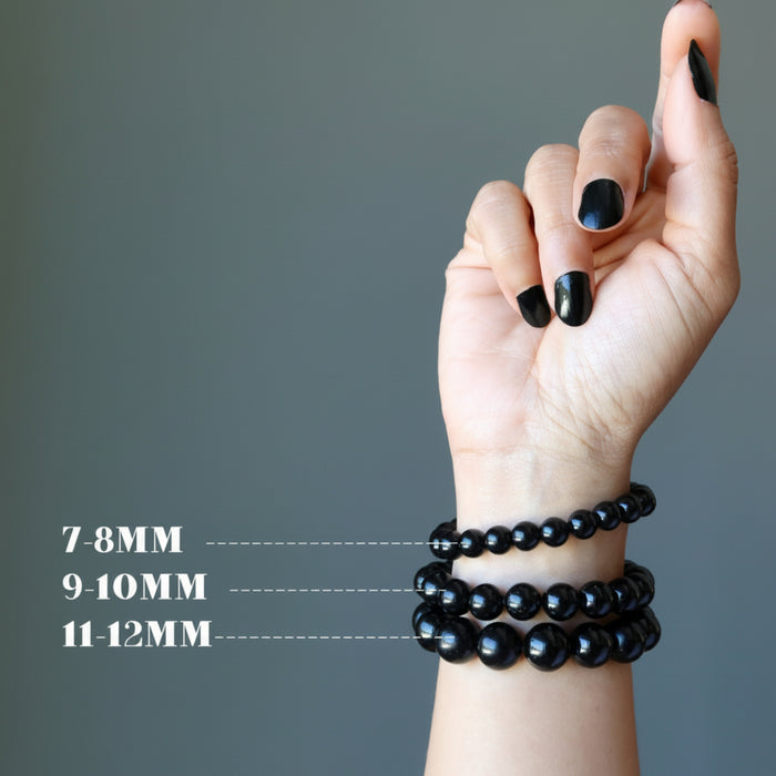 hand wearing three sizes of black tourmaline bracelets