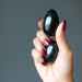 hand holding two black tourmaline eggs