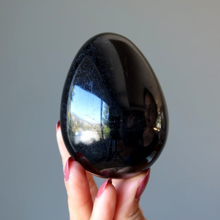 hand holding black tourmaline egg