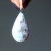 hands holding pink tourmaline pendant