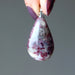 hands holding pink tourmaline pendant