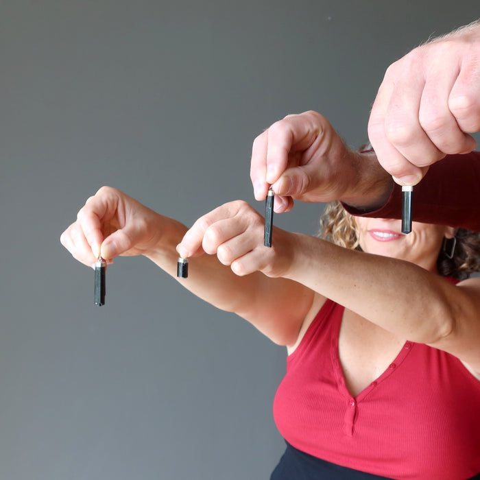 two models holding 4 Raw Black Tourmaline Pendants one on each hand