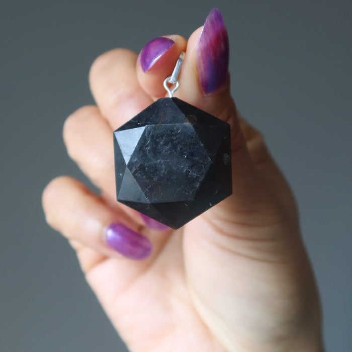 hand holding black tourmaline hexagon pendant