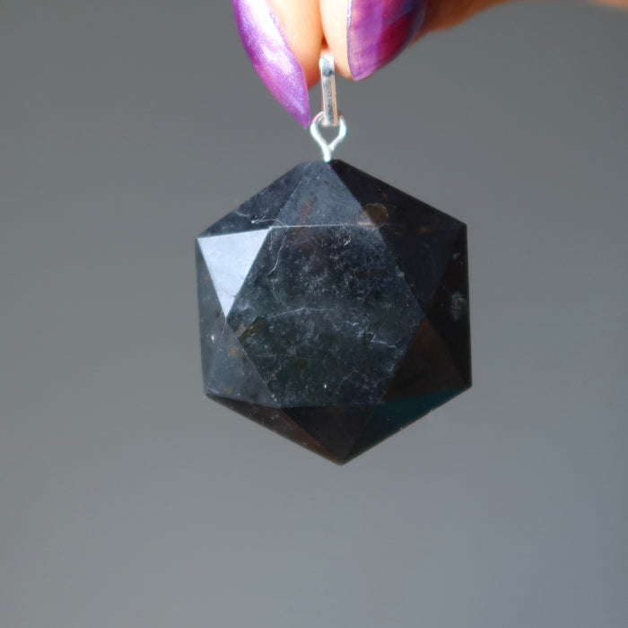 hand holding black tourmaline hexagon pendant