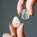 holding two tumbled citrine stones by finger tips from each hand