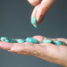 tumbled turquoise stones in hand
