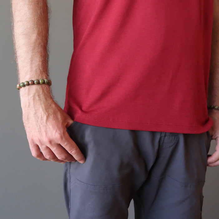 man's hand wearing pink and green round unakite beaded stretch bracelet